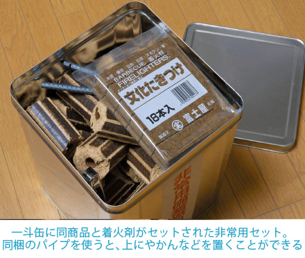 一斗缶に同商品と着火剤がセットされた非常用セット。同梱のパイプを使うと、上にやかんなどを置くことができる